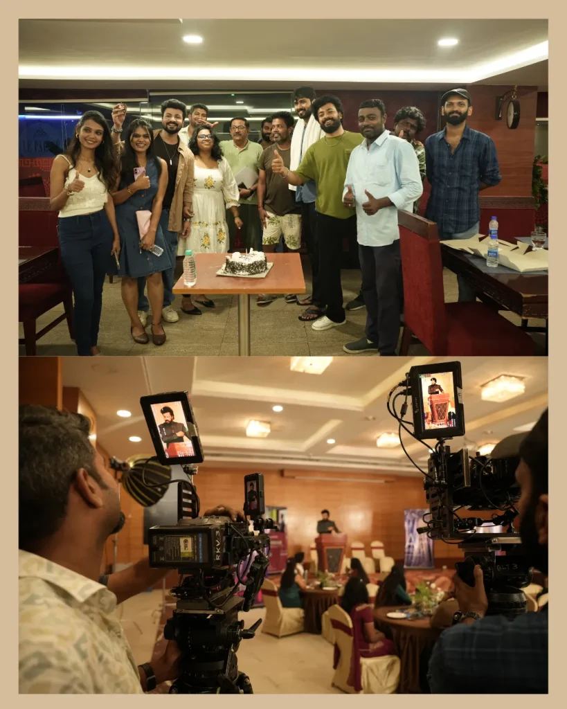 Group of people posing with a cake at a celebration while a film crew records the moment in a banquet hall.